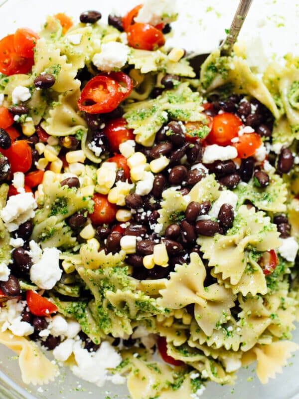 Healthy summertime pasta salad, made with jalapeรฑo-cilantro pesto, cherry tomatoes, corn, black beans and feta. You'll love this surprising combination!